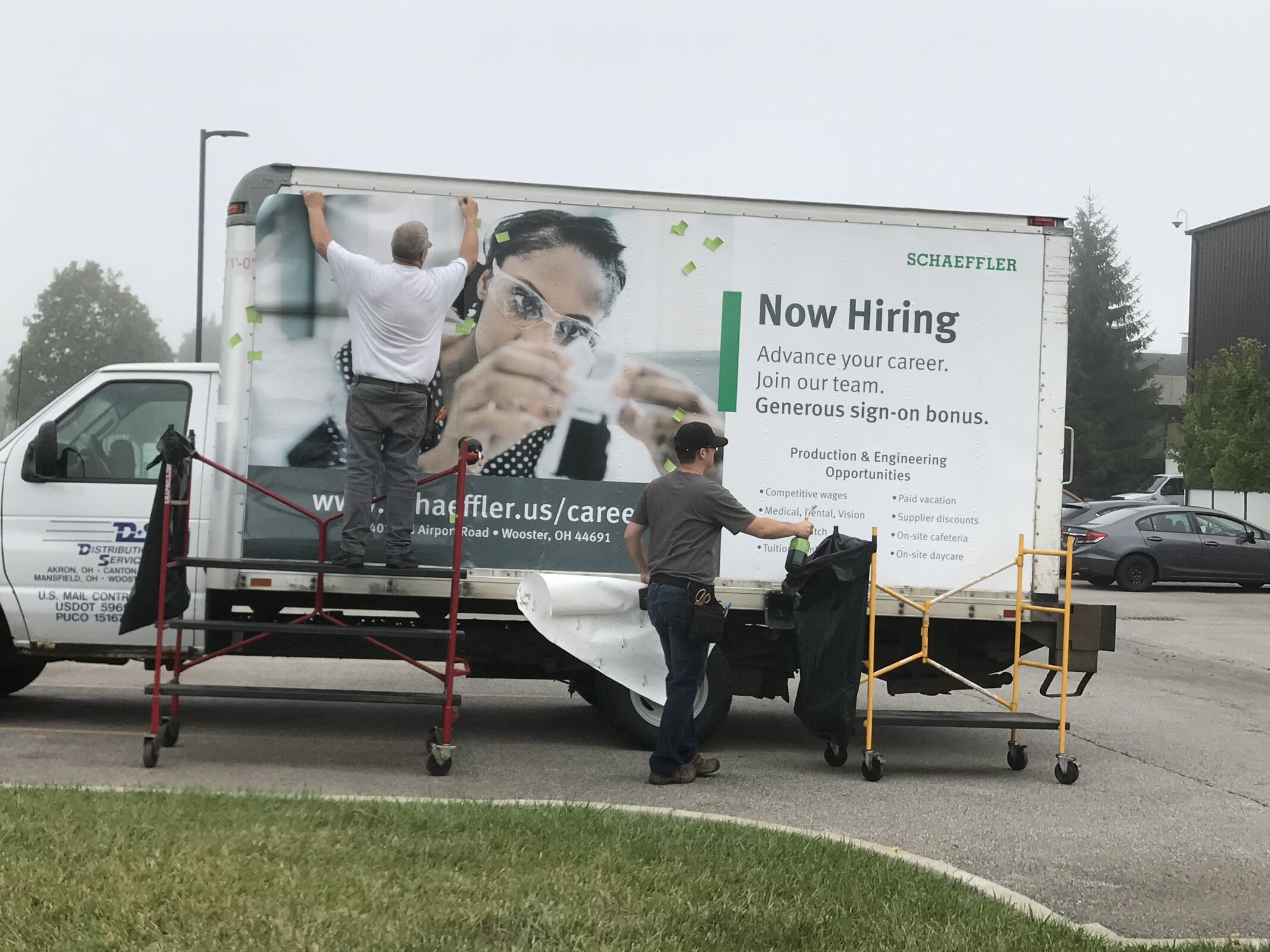 Large recruiting graphic being installed on a box truck